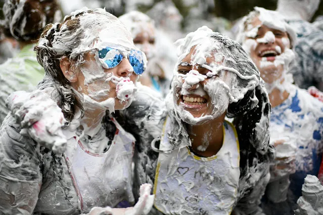 Students from St Andrews University indulge in a tradition of covering themselves with foam to honour the “academic family” on the lower college lawn on October 23, 2017, in St Andrews, Scotland. The “raisin weekend” stems from a gift – originally it was raisins, now it’s flour and shaving foam – traditionally given by first year students to their academic “parents” in gratitude for their guidance. Hundreds of students gathered to throw clumps of foam at each other, and it was all in the name of university tradition. The practice dates back around 600 years, and the name derives from when new students would offer a handful of raisins to older students in exchange for showing them around the university. A more typical present these days might be a bottle of wine. (Photo by Jeff J. Mitchell/Getty Images)