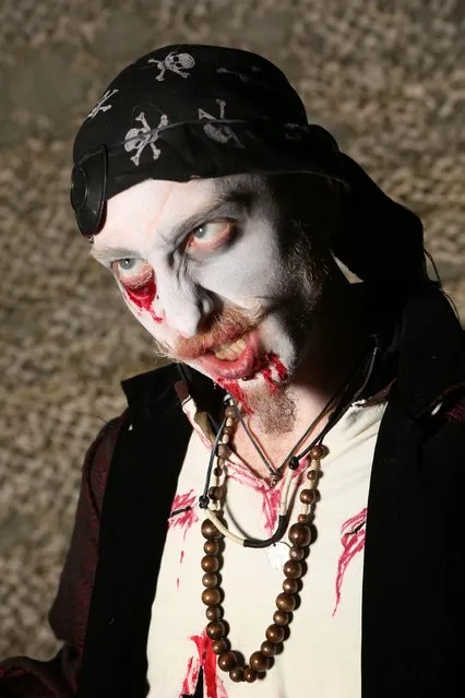 A visitor to the Shocktober Fest dressed as a zombie poses on October 6, 2012 in Turners Hill, England. People dressed as zombies from around the United Kingdom have converged on Tulleys Farm in an attempt to set a new Guinness World Record for the most zombies together in one place.  (Photo by Peter Macdiarmid)