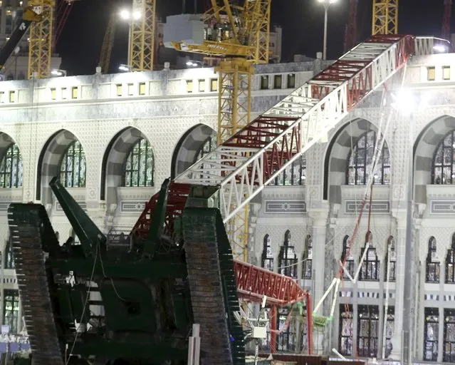 Saudi emergency crew stand near a construction crane after it crashed in the Grand Mosque in the Muslim holy city of Mecca, Saudi Arabia September 11, 2015. At least 107 people were killed when the crane toppled over at Mecca's Grand Mosque on Friday, Saudi Arabia's Civil Defence authority said, less than two weeks before Islam's annual haj pilgrimage. (Photo by Reuters/Stringer)