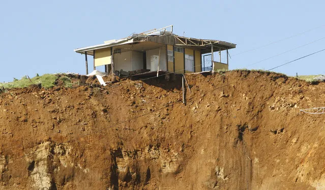 A house sits at the edge of a hill after a landslide caused by an earthquake in San Rafael de Vara Blanca, north of San Jose, January 10, 2009. (Photo by Roger Benavides/Reuters)