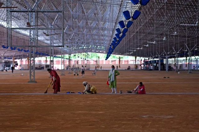 Volunteers clean the campus hall of Radha Soami Satsang Beas (RSSB), a spiritual organisation, which is being converted into a 10,000-bed COVID-19 coronavirus care centre, in New Delhi on June 24, 2020. The epidemic has badly hit India's densely populated major cities – including the national capital New Delhi and the financial hub Mumbai – with reports of hospitals being overwhelmed and patients struggling to find beds. (Photo by Money Sharma/AFP Photo)