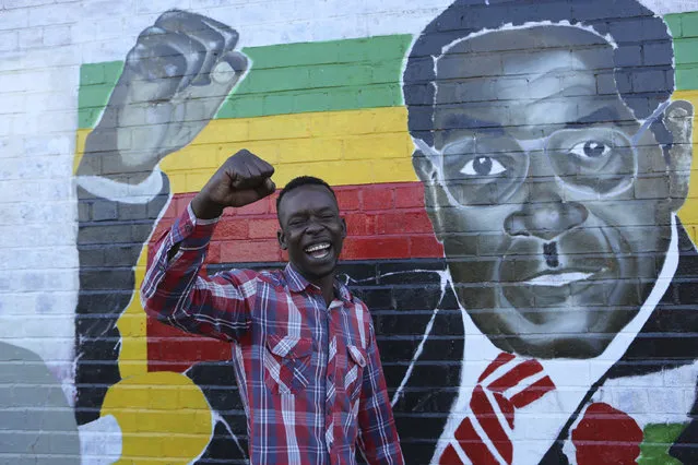 Terrence Chari poses as he mimics a painting of Zimbabwean President Robert Mugabe in Mbare Harare, Monday, November 20, 2017. Lawmakers with the ruling Zanu pf party gathered to meet on the fate of long time President Robert Mugabe, who has refused efforts to step down. (Photo by Tsvangirayi Mukwazhi/AP Photo)