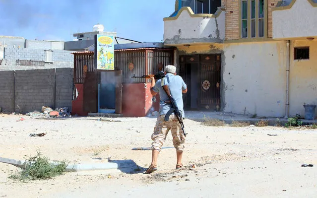 A member of Libyan forces allied with the UN-backed government fires a weapon towards Islamic State militants in neighbourhood Number One in central Sirte, Libya August 28, 2016. (Photo by Ismail Zitouny/Reuters)