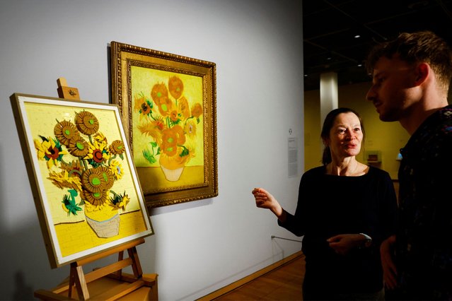 Curator at Van Gogh Museum Nienke Bakker and LEGO Product Designer Stijn Oom talk infront of a LEGO brick version of Van Gogh's Sunflowers painting next to the original version of the painting displayed at the Dutch Van Gogh Museum in Amsterdam, Netherlands on February 28, 2025. (Photo by Piroschka van de Wouw/Reuters)