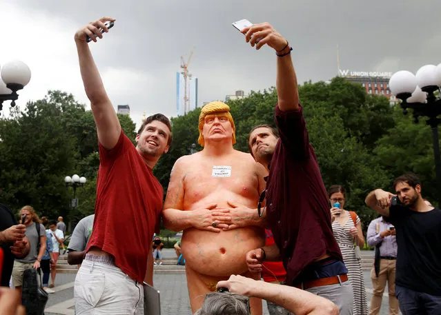 People pose for selfies with a naked statue of U.S. Republican presidential nominee Donald Trump that was left in Union Square Park in New York City, U.S. August 18, 2016. (Photo by Brendan McDermid/Reuters)