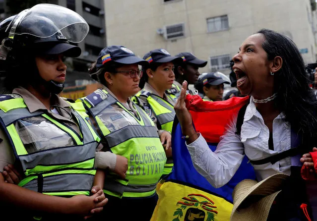 A demonstrator shouts slogans in front of police officers during a women's march to protest against President Nicolas Maduro's government in Caracas, Venezuela May 6, 2017. The women's marches, which took place in most major cities around the country, were the latest in five weeks of sustained protests against Maduro. In Caracas, marchers sang the national anthem and shouted 'We want elections!'. They were halted at various points by lines of policewomen and National Guard troops with armoured cars. Carlos Garcia Rawlins: “Unlike most of the previous protests, after many hours the protesters decided to leave and there were no violent clashes”. (Photo by Carlos Garcia Rawlins/Reuters)