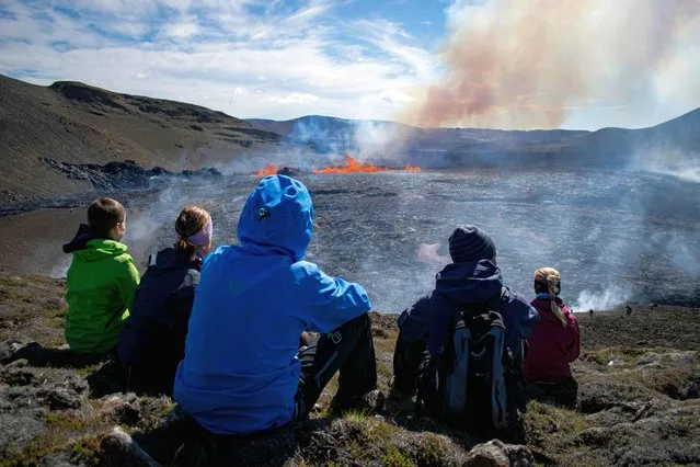 People visit the scene of the newly erupted volcano taking place in Meradalir valley, near mount Fagradalsfjall, Iceland on August 4, 2022. The eruption is some 40 kilometres (25 miles) from Reykjavik, near the site of the Mount Fagradalsfjall volcano that erupted for six months in March-September 2021, mesmerising tourists and spectators who flocked to the scene. (Photo by Jeremie Richard/AFP Photo)