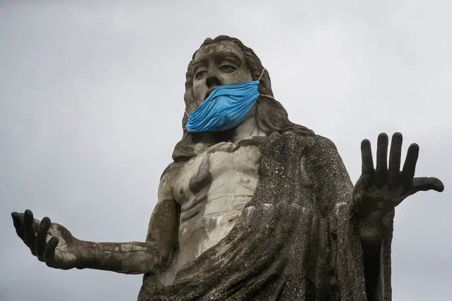 A view of a statue of Jesus Christ adorned with a mask to raise awareness for its use in the midst of the ongoing coronavirus pa​ndemic, in the Petare sector, Caracas, Venezuela, 03 August 2020. (Photo by Miguel Gutierrez/Reuters)