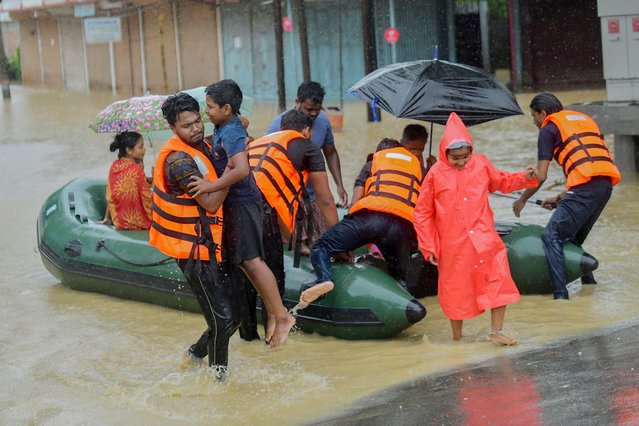 A rescue team helps flood-affected residents disembark from an inflatable boat in Badkhal village, near Agartala, India, on June 1, 2025. (Photo by Abhisek Saha/Middle East Images via AFP Photo)