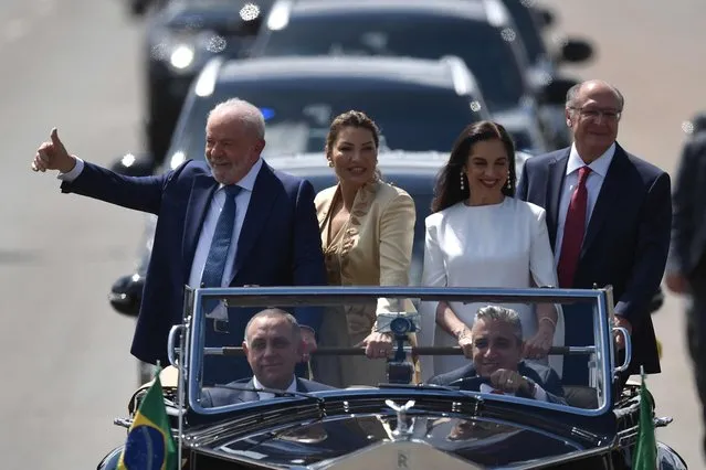 Brazil's President-elect Luiz Inacio Lula da Silva (L) gives the thumb, accompanied by his wife Rosangela da Silva (2-L), his Vice-President-elect Geraldo Alckmin (R), and his wife, Maria Lucia Ribeiro Alckmin, on their way to the National Congress for their inauguration ceremony, in Brasilia, on January 1, 2023. (Photo by Carl de Souza/AFP Photo)