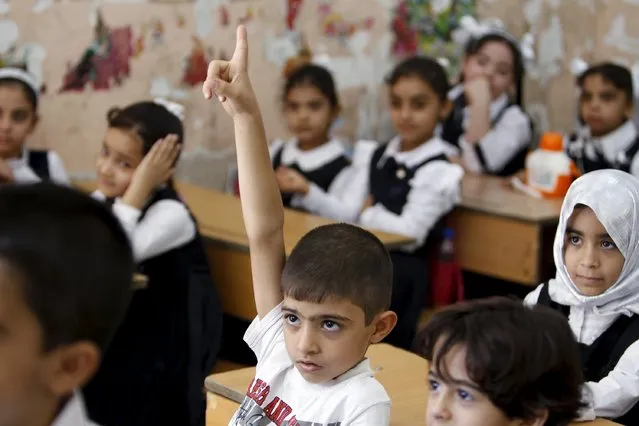A student raises his hand while attending the first day of the new school term at a primary school in Baghdad, October 18, 2015. (Photo by Ahmed Saad/Reuters)