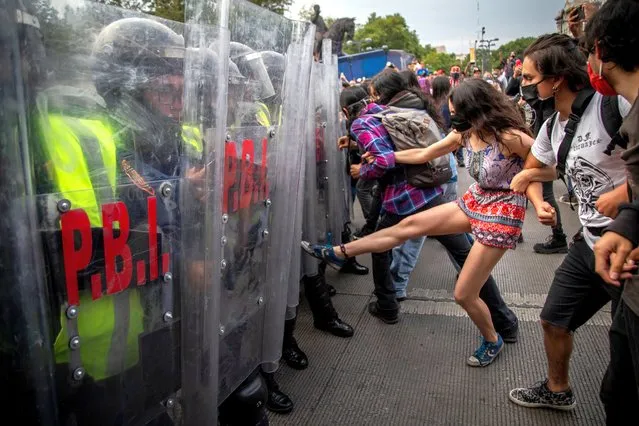 Juvenile demonstrators step on a police chain in Mexico, Mexico City on September 26, 2020. More than 2500 people take part in a march to commemorate the sixth anniversary of the disappearance of 43 students in Ayotzinapa. Six years after the disappearance of the students in southwestern Mexico, the government has promised further investigations. (Photo by Jair Cabrera Torres/dpa)