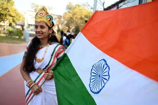 A school student holds the flag of India before taking part in a ceremony during the Republic Day celebrations at the railway sports complex ground in Secunderabad, the twin city of Hyderabad on January 26, 2023. (Photo by Noah Seelam/AFP Photo)