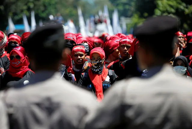 Police stand in front of Indonesian union workers protesting against a government tax amnesty near the presidential palace in Jakarta, Indonesia September 29, 2016. (Photo by Darren Whiteside/Reuters)