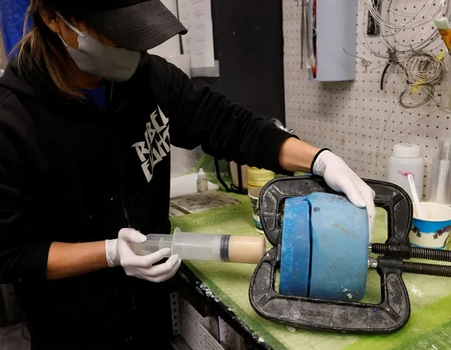 A staff of “Amazing studio JUR”, puts silicon into a mould, as he works to produce a hyper realistic flesh-like object, created by Masataka Shishido, also known as DJ Doooo, in the studio in Tokyo, Japan on February 2, 2023. (Photo by Kim Kyung-Hoon/Reuters)