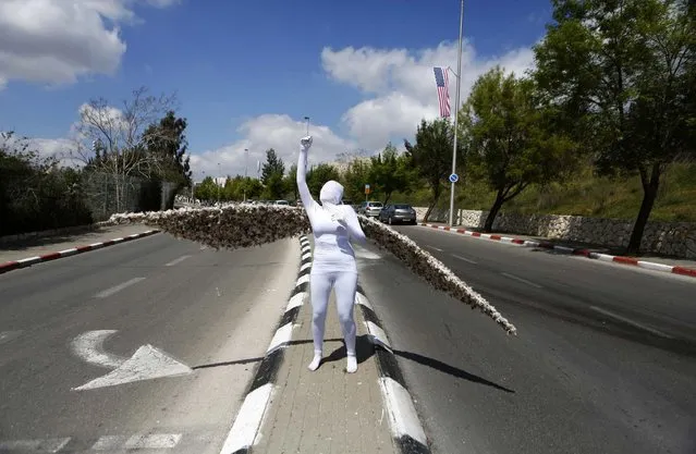 Reut Harel, a street performer, stands in a pose as she promotes the 2013 Jerusalem Science Festival March 18, 2013. The Jerusalem municipality and local museums are hosting a five-day festival focusing on developments in the science world. (Photo by Baz Ratner/Reuters)