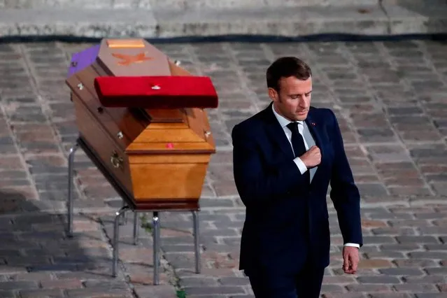 French President Emmanuel Macron pays his respects by the coffin of Samuel Paty's coffin inside Sorbonne University's courtyard in Paris on October 21, 2020, during a national homage to French teacher Samuel Paty, who was beheaded for showing cartoons of the Prophet Mohamed in his civics class. France pays tribute on October 21 to a history teacher beheaded for showing cartoons of the Prophet Mohamed in a lesson on free speech, an attack that has shocked the country and prompted a government crackdown on radical Islam. Seven people, including two schoolchildren, will appear before an anti-terror judge for a decision on criminal charges over the killing of 47-year-old history teacher. (Photo by Francois Mori/AFP Photo)