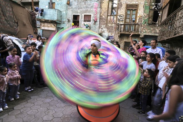 Rehab, a female whirling dervish, spins during a charity day organized by a group of volunteers who distribute toys and food at Darb Shughlan popular district in Cairo, Friday, April 11, 2025. (Photo by Amr Nabil/AP Photo)