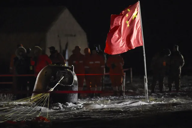 In this photo released by Xinhua News Agency, recovery crews look at the capsule of the Chang'e 5 probe after its successful landing at the main landing site in Siziwang district, north China's Inner Mongolia Autonomous Region on Thursday, December 17, 2020. A Chinese lunar capsule returned to Earth on Thursday with the first fresh samples of rock and debris from the moon in more than 40 years. (Photo by Peng Yuan/Xinhua via AP Photo)