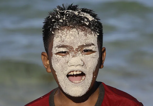 A Filipino boy with sand on his face plays, on the country's most famous beach resort island of Boracay, in central Aklan province, Philippines, Tuesday, April 24, 2018. Thousands of workers will be affected when the island closes after Philippine President Rodrigo Duterte ordered its closure on April 26 for up to six months after saying the waters off its famed white-sand beaches had become a “cesspool” due to overcrowding and development. (Photo by Aaron Favila/AP Photo)