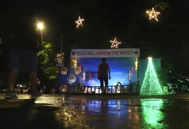 A message that reads “Jesus will unmask the world” is displayed on a Christmas crib lit up with lights on the eve of Christmas in Mumbai, India, Thursday, December 24, 2020. Though Hindus and Muslims comprise the majority of the population in India, Christmas is a national holiday celebrated with much fanfare. (Photo by Rafiq Maqbool/AP Photo)