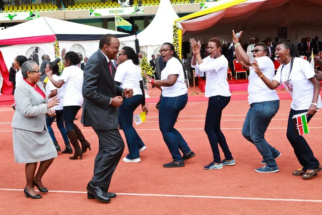 Front row President Uhuru Kenyatta (R), and First lady Margaret Kenyatta (L), join Kenyan youths in singing and dancing as they await the arrival of Pope Francis (not pictured), where he addressed thousands of youths at the Kasarani sports center in Nairobi, Kenya, 27 November 2015. Pope Francis is on his last day in Kenya part of his three day tour into the country as his first stop on a three-nation Africa tour. (Photo by Daniel Irungu/EPA)
