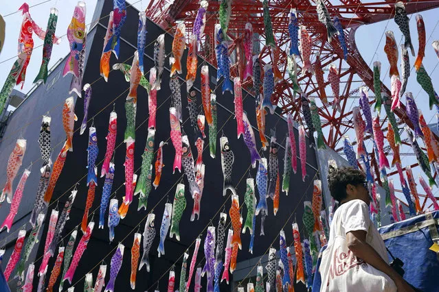 Colorful carp streamers flutter in the air at the bottom of Tokyo Tower in Tokyo, Thursday, May 4, 2023, on the eve of Children's Day national holiday. It is a national tradition in Japan to fly carp streamers on Children's Day. (Photo by Eugene Hoshiko/AP Photo)