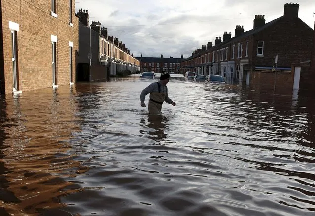 A local man wades through flood water on a residential street in Carlisle, Britain December 6, 2015. (Photo by Phil Noble/Reuters)