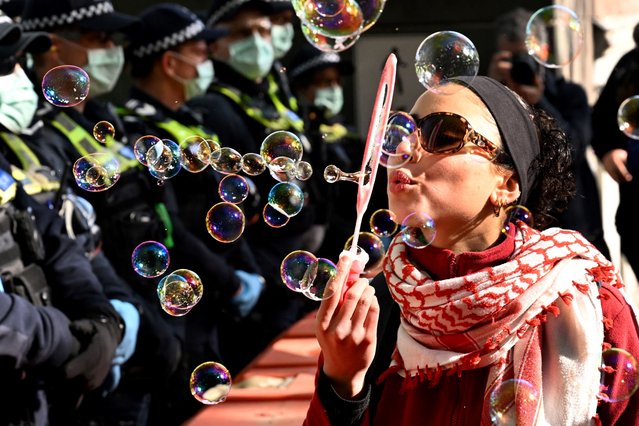 A protester blows bubbles at police during protests at the Land Forces 2024 arms fair in Melbourne on September 12, 2024. (Photo by William West/AFP Photo)