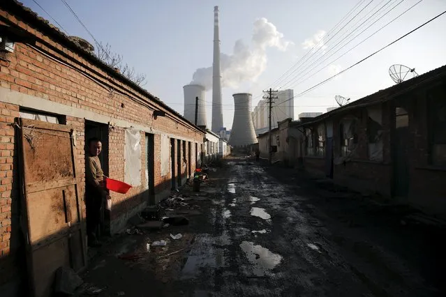A migrant worker steps out of his accommodation in an area next to a coal power plant in Beijing during a smog-free and also the last day of the city's first "red alert" for air pollution, December 10, 2015. (Photo by Damir Sagolj/Reuters)