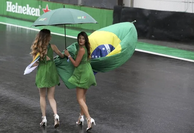 Formula One, F1, Brazilian Grand Prix, Circuit of Interlagos, Sao Paulo, Brazil on November 13, 2016. Race hostesses carry a Brazilian flag before the start of the race. (Photo by Paulo Whitaker/Reuters)