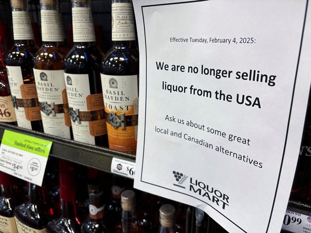 A sign notifying customers that a store will stop selling U.S. liquor from Tuesday, in response to U.S. President Donald Trump's imposition of tariffs on Canada, is displayed on a shelf carrying U.S. alcohol in Winnipeg, Manitoba, Canada, on February 2, 2025. (Photo by Ed White/Reuters)