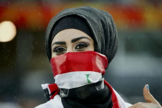 An Iraq fan waits in the rain for the start of their Asian Cup semi-final soccer match against South Korea at the Stadium Australia in Sydney January 26, 2015. (Photo by Edgar Su/Reuters)