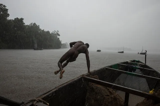 Sand diver, Cameroon, 2017. These men dived for brickies sand in the fast moving Douala Estuary in eastern Cameroon. The work was brutal and dangerous and the miners dived around the low tide. Deaths occurred periodically and some of the hazards included sand being ingested into ears and major orifices, the benz, being knocked out on the hull of the boat when surfacing too quickly in the wrong place and then drowning on being washed away by the tide, venomous snakes coming down on floating weed mates, stingrays, etc. (Photo by Hugh Brown/South West News Service)