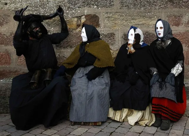A reveller dressed as a “Diablo de Luzon” (L) (Luzon Devil) sits next to others dressed as “Mascaritas” during carnival celebrations in Luzon February 14, 2015. (Photo by Sergio Perez/Reuters)