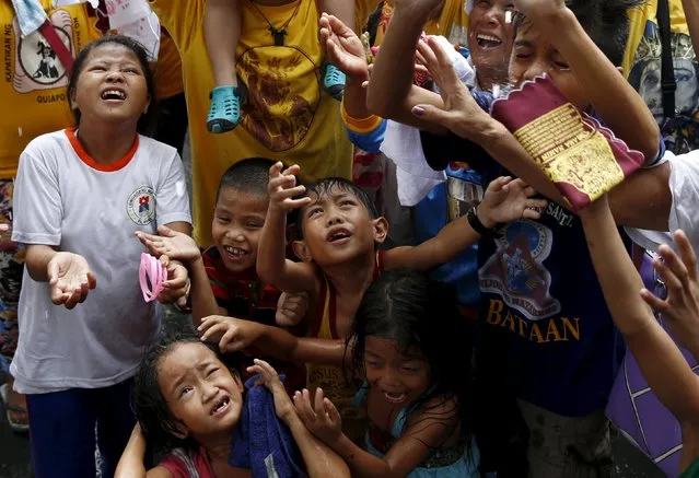 Children and other devotees wait to be sprinkled with holy water two days before the annual procession of the Black Nazarene in Manila January 7, 2016. (Photo by Erik De Castro/Reuters)