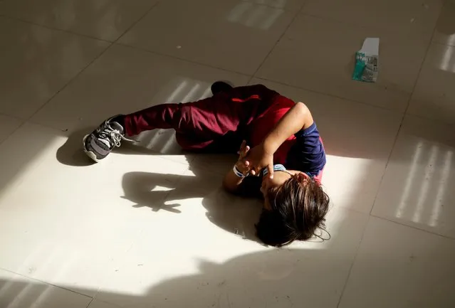 A migrant child from Central America plays with his own shadow inside the office of the Center for Integral Attention to Migrants (CAIM) after being deported with his mother from the United States, in Ciudad Juarez, Mexico on March 15, 2021. (Photo by Jose Luis Gonzalez/Reuters)