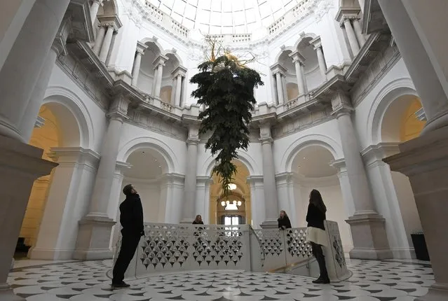 Employees and visitors view a Christmas tree, by Iranian born artist Shirazeh Houshiary as part of the Festive Commission at the entrance to the Tate Britain gallery in London Britain, December 1, 2016. (Photo by Toby Melville/Reuters)