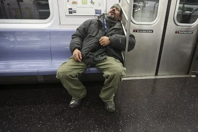 A man sleeps on the subway as it pulls into the 34th Street Hudson Yards station in the Manhattan borough of New York, January 6, 2016. (Photo by Carlo Allegri/Reuters)