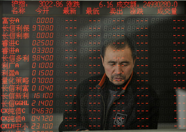 An investors face is reflected int he monitor as the Shanghai index rose 0.2% to 3022.86 points in Taiyuan, China, January 12, 2016. (Photo by Tpg via ZUMA Press)