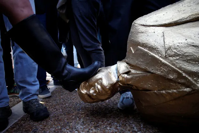 A woman steps on a statue of Israeli Prime Minister Benjamin Netanyahu, which was created by Israeli sculptor Itay Zalait as a political protest against Netanyahu, as it is taken away by the artist from a square outside Tel Aviv's city hall, Israel December 6, 2016. (Photo by Baz Ratner/Reuters)