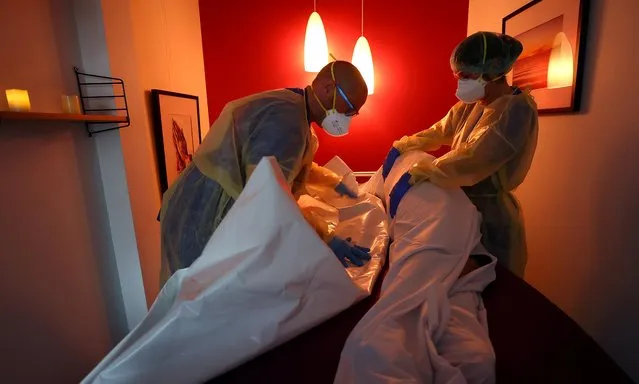 Medical personnel prepares the body of a patient who died of COVID-19 inside the “farewell room” at the coronavirus disease (COVID-19) Intensive Care Unit (ICU) of the “Klinikum Darmstadt” clinic in Darmstadt, Germany, May 20, 2021. (Photo by Kai Pfaffenbach/Reuters)