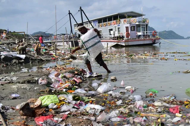 Indian ragpicker collects recyclable material from a polluted area of the river Brahmaputra on World River Day in Guwahati, India on September 24, 2023. (Photo by Anuwar Hazarika/NurPhoto/Rex Features/Shutterstock)