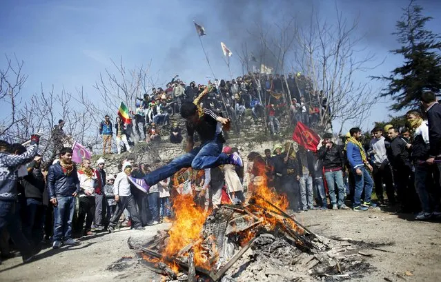 A Turkish Kurdish man jumps over a bonfire during a rally celebrating Newroz, which marks the arrival of spring and the new year, in Istanbul March 22, 2015. Jailed Kurdish rebel leader Abdullah Ocalan said on Saturday his militant group's three-decade insurgency against the Turkish state had become “unsustainable” but stopped short of declaring an immediate end to its armed struggle. (Photo by Murad Sezer/Reuters)