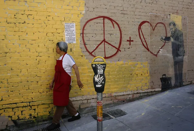 A woman walks past a painting, believed to be the work of elusive British street artist Banksy, in the Chinatown section of San Francisco, May 4, 2010. (Photo by Robert Galbraith/Reuters)