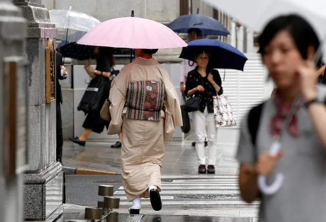 A woman, dressed in a traditional Japanese kimono, holds an umbrella as she  walk on a street as Typhoon Malakas approaches the region in Tokyo, Japan, September 20, 2016. (Photo by Toru Hanai/Reuters)
