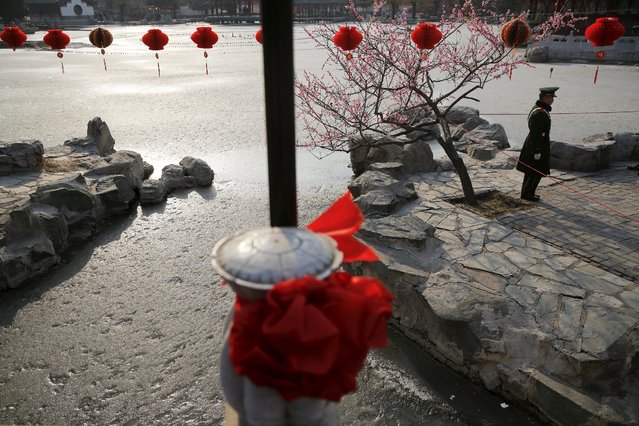 A paramilitary policeman secures the area around a frozen pond as the Chinese Lunar New Year, which welcomes the Year of the Monkey, is celebrated at Daguanyuan park, in Beijing, China February 10, 2016. (Photo by Damir Sagolj/Reuters)