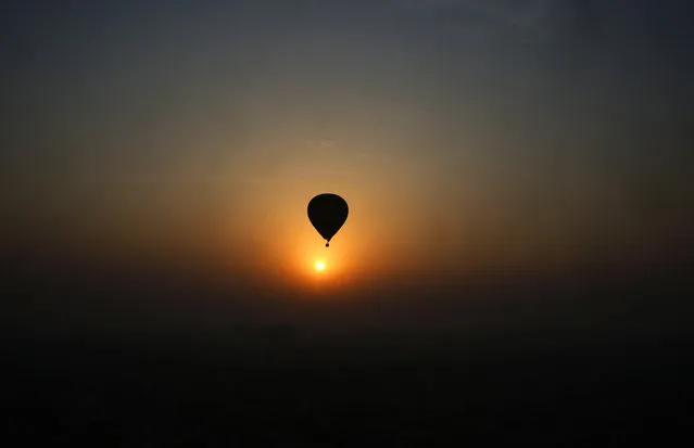 A hot air balloon flies against a sun rise during Lucknow balloon festival in Lucknow, India, Monday, February 15, 2016. The three-day festival is to boost the tourism and generate more employment opportunities in the state of Uttar Pradesh. (Photo by Rajesh Kumar Singh/AP Photo)