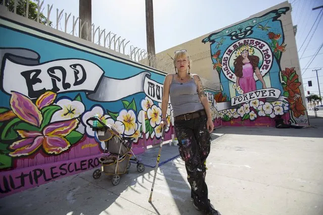 Street artist Lydia Emily Archibald, who was diagnosed with Multiple Sclerosis in 2012, poses by her mural aimed at raising awareness about the disease in Los Angeles, California April 9, 2015. (Photo by Mario Anzuoni/Reuters)