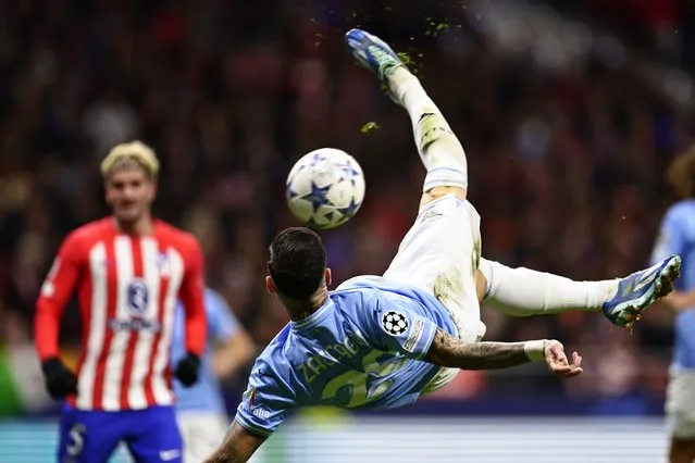 Lazio's Mattia Zaccagni tries an overhead kick on goal watched by Atletico Madrid's Rodrigo De Paul during a Group E Champions League soccer match between Atletico Madrid and Lazio at the Metropolitano stadium in Madrid, Spain, Wednesday, December 13, 2023. (Photo by Pablo Garcia/AP Photo)
